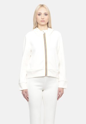 Felpa bianca con zip e bande a contrasto al centro, dotata di cappuccio con coulisse e polsini a coste, abbinata a pantaloni coordinati.