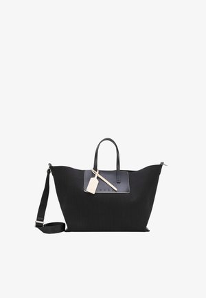Velika črna torba tote z dvojno ročico, nastavljivim ramenskim trakom, sprednjim žepom in priloženo bež etiketo za prtljago.