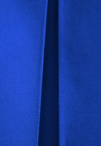 Niebieska tkanina o gładkiej fakturze, z subtelnym połyskiem i równomiernym splotem, prezentowana w złożonym układzie, ukazującym linie.