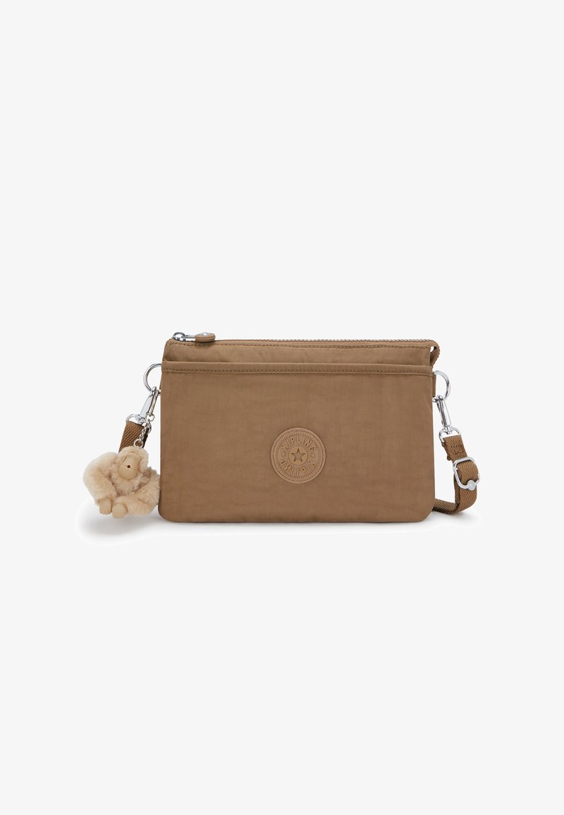 Borsa a tracolla in tessuto marrone con un patch logo, chiusura con zip, tracolla rimovibile e un charm a forma di scimmia pelosa attaccato. Texture liscia.