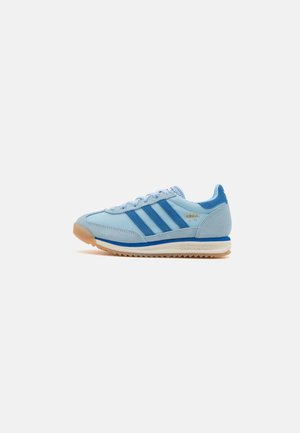 Jasnoniebieski but sportowy Adidas SL 72 z ciemnoniebieskimi paskami, gumową podeszwą i białą śródpodeszwą, przedstawiony z boku na białym tle.