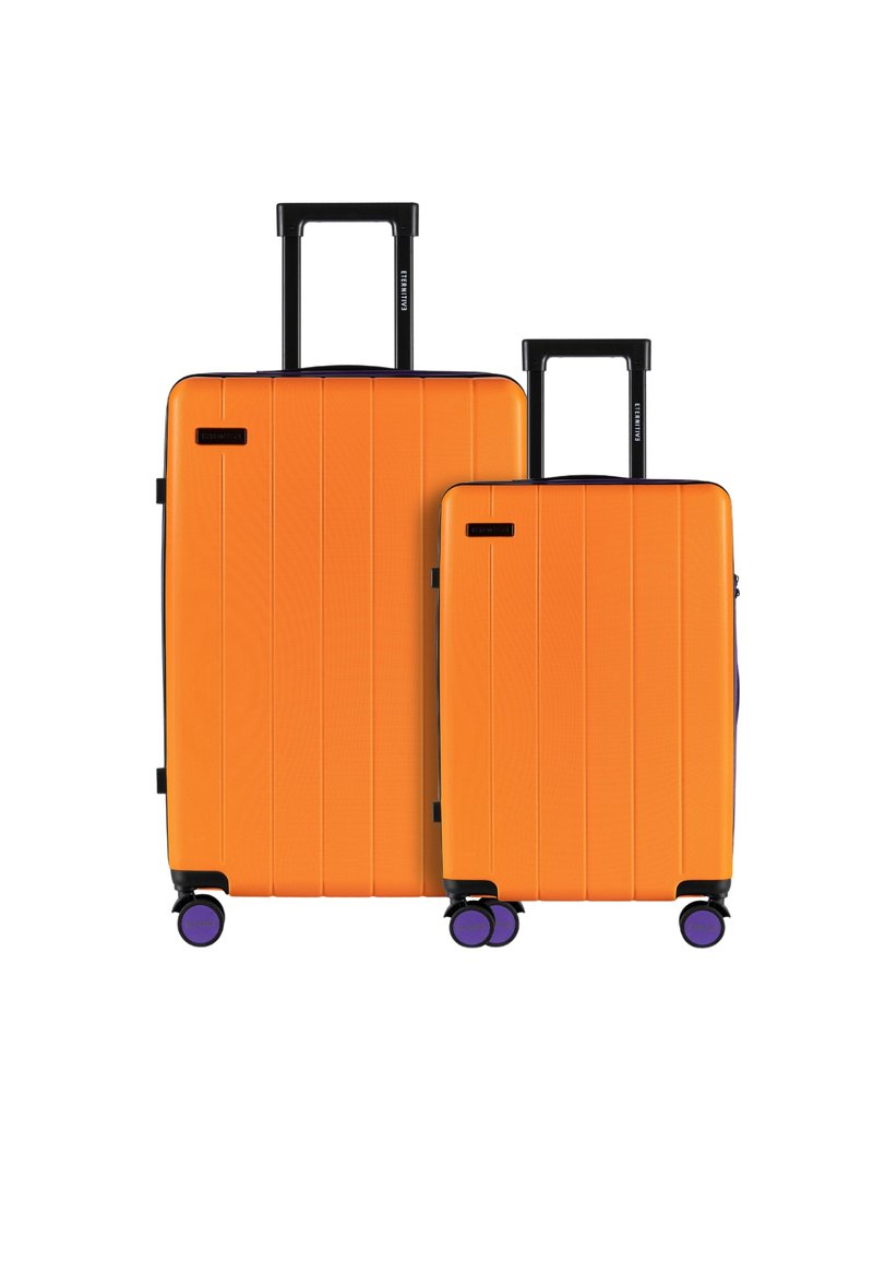 Dwie twarde walizki w jaskrawym pomarańczowym kolorze, z teksturowanymi powierzchniami, poziomymi rowkami, czarnymi uchwytami i fioletowymi kołami.