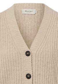 Beżowy dziergany kardigan z dekoltem w serek, ozdobiony fakturowanym wzorem, żebrowanym wykończeniem i dwoma czarnymi guzikami z przodu.