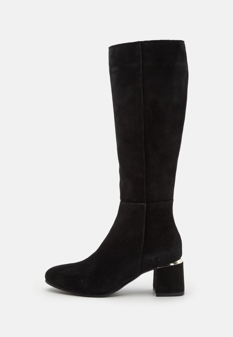 Bota de ante negra hasta la rodilla con punta redonda, tacón grueso y acento metálico en la base. Textura suave y forma ajustada.