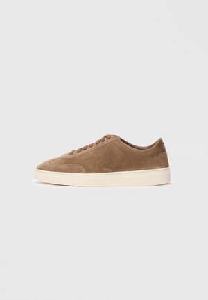 Baskets basses en cuir suédé marron avec semelle et lacets crème, ornées sur le côté du logo "BOSS", présentées sur un fond blanc.