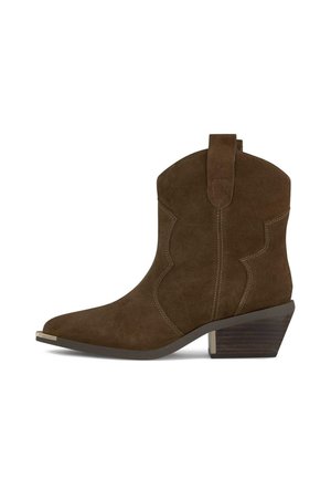 Bottine en daim marron avec talon bloc en bois incliné, coutures décoratives et languette de tirage sur le côté, sur fond blanc.