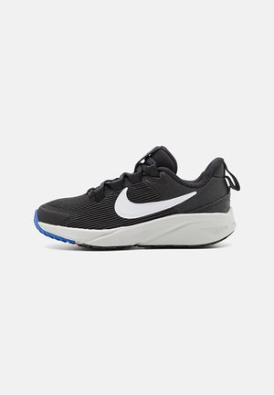 Zapatilla deportiva negra con parte superior texturada, logo blanco, lengüeta acolchada y suela gris duradera con acentos azules.