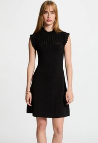 Black dress with a fitted bodice, pleated texture at the neckline, and ruffled short sleeves. Soft material with a flared skirt.