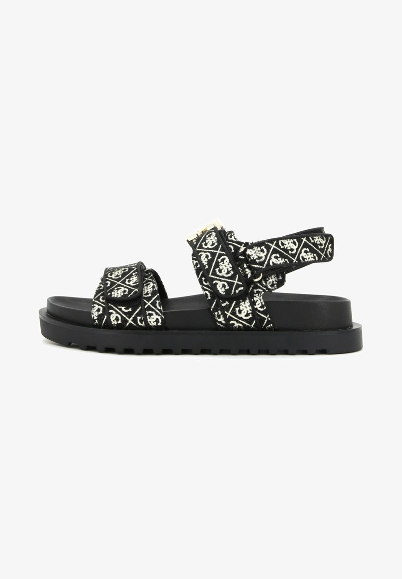 Black and white patterned sandals with thick fabric straps, adjustable buckle, and a flat, textured black rubber sole.