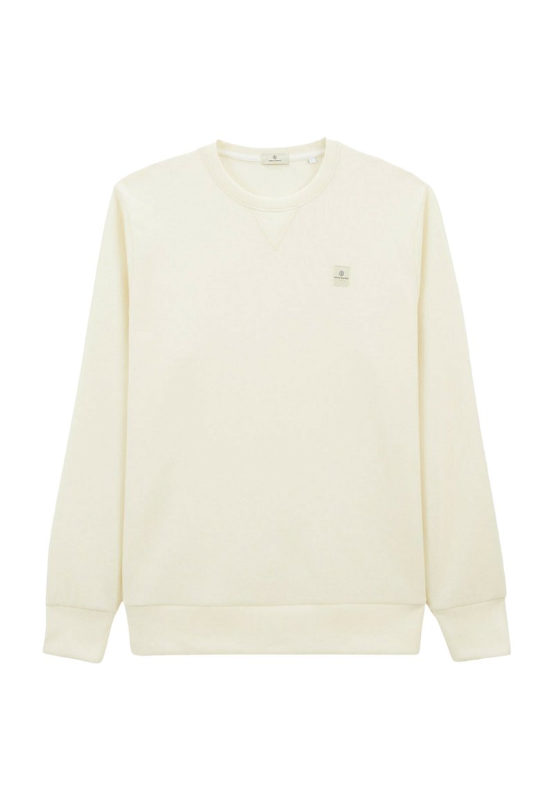 Sweatshirt couleur crème avec manches longues, bords côtes aux poignets et à l'ourlet, design en V, comportant un petit patch logo sur le haut de la poitrine gauche.