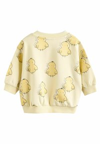 Dzeltenā sporta krekls ar cāļu rakstu, ribināta apkakle un aproces. Mīksts audums, kas nodrošina brīvu piegriezumu un jautru dizainu.