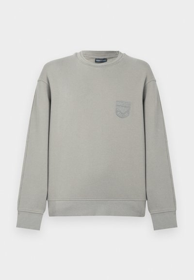 Sweatshirt cinzenta de algodão com mangas compridas, punhos canelados e um pequeno logótipo bordado no peito. Decote redondo e corte descontraído.