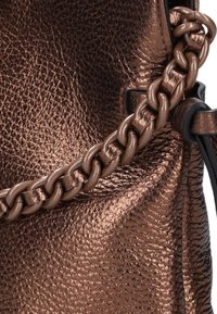 Bruine leren tas met een gestructureerde afwerking, voorzien van een dikke, in elkaar grijpende kettingstrap en contrasterende zwarte accenten.