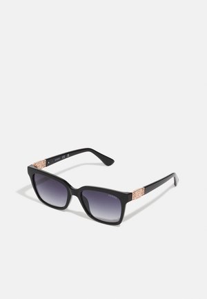 Black sunglasses with a square shape and gradient lenses. Metal accents in rose gold on the temples feature a geometric pattern.