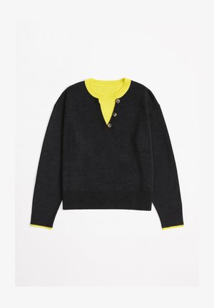 Tmavosivý sveter so žltým golierom a detailmi. Má výstrih do V a tri hnedé gombíky na légach. Rebrované manžety a spodný lem.