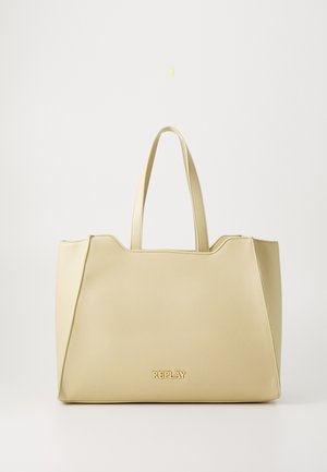 Sac fourre-tout beige en matériau lisse, avec deux anses et un logo doré "REPLAY" à l'avant. Design simple avec des côtés angulaires.