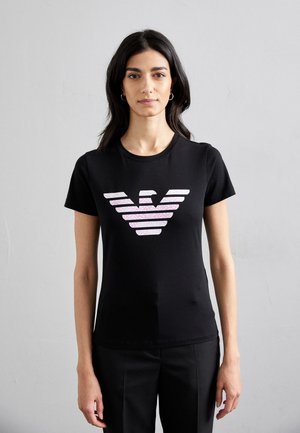 T-shirt nera a maniche corte con logo stilizzato a strisce rosa e bianche sul petto. Materiale in cotone morbido e elastico.
