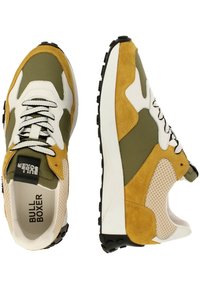 Oliwkowe i żółte zamszowe sneakersy z białymi akcentami, siateczkowymi bokami i czarnymi gumowymi podeszwami; posiadają okrągłe sznurowadła i brandowane języki.