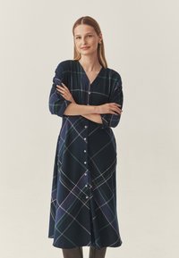 Tengerészkék ingruha zöld és rózsaszín kockás mintával. Jellemzője a V-nyak, gombos elülső rész és háromnegyedes ujj. Puha anyag.