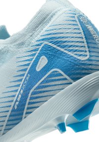 Zapatilla deportiva de color azul claro con un upper texturizado, rayas azules dinámicas y una suela blanca con acentos azules y puntas para tracción.