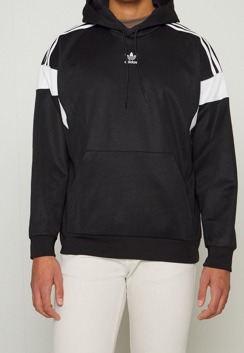 Black Adidas hooded sweatshirt with white side panels, drawstring hood, front pocket, and ribbed cuffs. Made from a smooth, stretchy fabric.