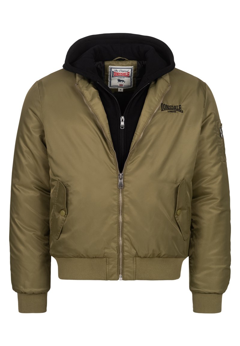Giacca bomber verde oliva con chiusura a zip, polsini a costine e due tasche frontali, con un black hoodie indossato sotto.