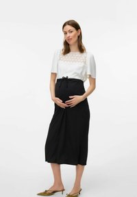 Completo premaman composto da una blusa bianca testurizzata con dettagli in pizzo e una gonna nera a ginocchio con dettagli arricciati e vita con cordoncino.