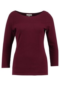 Top bordeaux a maniche lunghe con scollatura rotonda, dettagli testurizzati sulle spalle e un corpo aderente e liscio. Realizzato in tessuto morbido e elasticizzato.