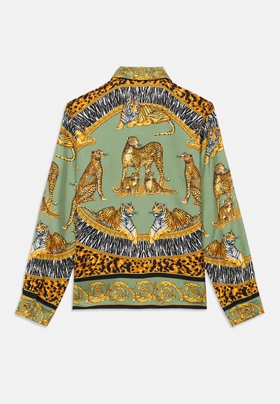 Košulja s dugim rukavima na zelenoj osnovi ukrašena zlatnim i narančastim životinjskim uzorcima, uključujući tigrove i leoparde, uokvirena crnim i leopard uzorcima.