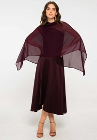 Vestido burdeos con una superposición transparente, silueta fluida y dobladillo hasta el tobillo. Incluye un escote alto y un acabado suave y texturizado.