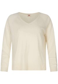 Pull en V crème, manches longues, bords côtelés aux poignets et à l'ourlet, texture tricotée douce, léger, design simple sans motifs ni accessoires.