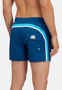 Marine zwemshorts met lichtblauwe en witte zijstrepen. Voorzien van een achterzak met een logo-label en een oogje voor afvoer. Elastische tailleband.