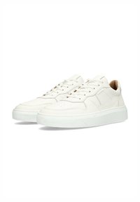 Sneakers bianchi in pelle con finitura liscia, dotati di punta perforata, lacci piatti e una suola in gomma spessa per un'altezza maggiore.