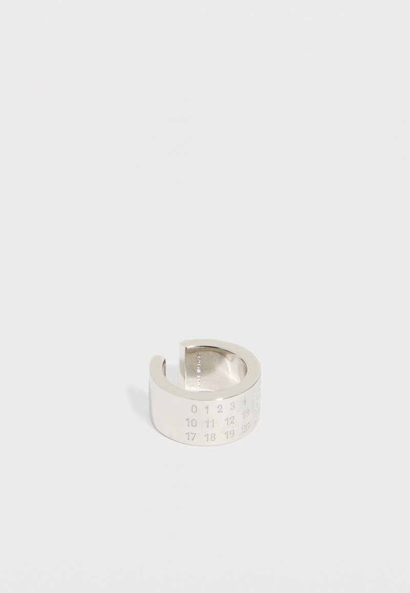 Ευρύ ανοιχτό ασημένιο δαχτυλίδι χαραγμένο με αριθμούς που είναι διατεταγμένοι σε σειρές από το 0 έως το 30 σε απλό λευκό φόντο.