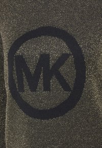 Gros plan sur un tissu texturé avec un logo circulaire noir portant les lettres "MK" au centre.