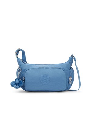Lyseblå crossbody-taske med justerbar rem, frontlomme, sidelomme med lynlås og en lille blå pelsede nøglering formet som en abe.