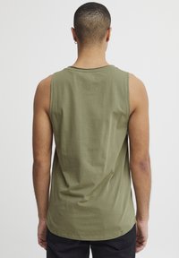 Olivgrünes ärmelloses Tanktop aus weicher Baumwolle, mit rundem Ausschnitt und lässiger Passform, mit längerer hinterer Saum.