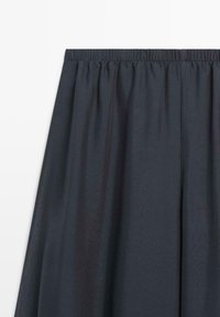 Donker marineblauwe rok met elastische tailleband, geplooide stof die zachte plooien creëert, gladde textuur, geen zichtbare patronen of versieringen.