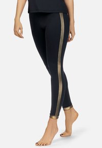Czarne legginsy z metalicznie złotymi paskami po bokach i mankietami. Gładka tekstura, dopasowany krój, długość do kostek i elastyczny materiał dla komfortu.