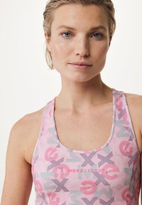 Top da palestra rosa con un motivo geometrico e lettere e forme stilizzate. Il materiale appare liscio ed elastico.