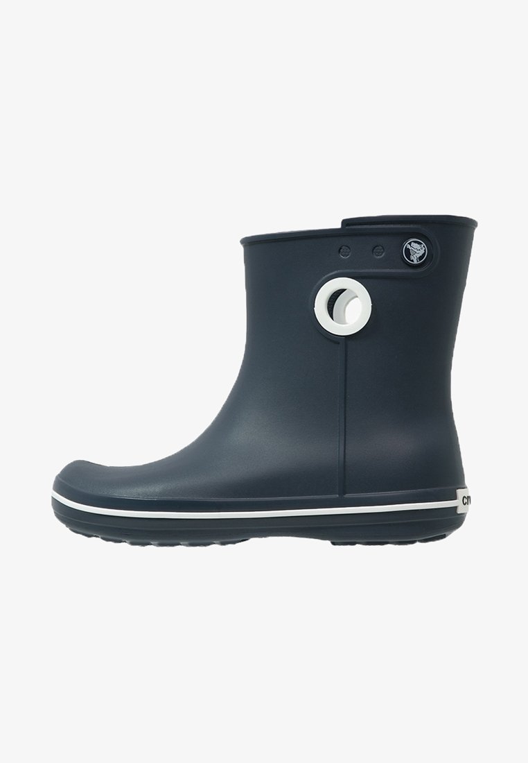 Bottine imperméable bleu marine avec un trou de ventilation circulaire blanc et une bande blanche le long de la semelle, conçue pour les temps pluvieux.