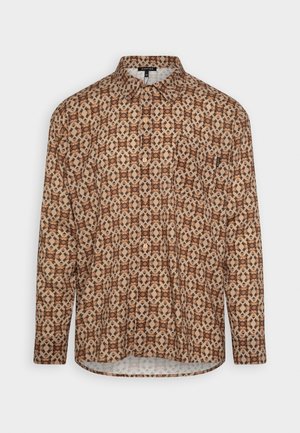 Langærmet skjorte med knapper foran, beige baggrund og et indviklet geometrisk mønster i brune og sorte nuancer.