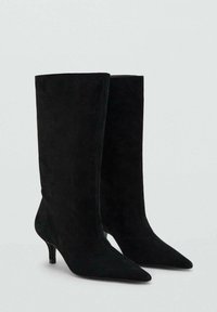 Bottes noires en daim à cheville avec un bout pointu et un talon fin de hauteur moyenne. Texture lisse et ajustement serré avec une tige haute.