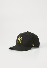 Gorra negra con visera curva, que presenta un prominente logo bordado en amarillo "NY" en la parte frontal y un pequeño '47' amarillo en el costado.