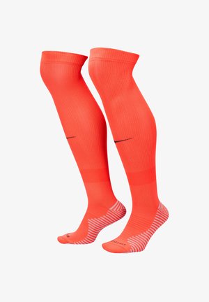 Calze fino al ginocchio di un vivace arancione, con una texture a coste e punta rinforzata. Design a strisce alla base e un sottile dettaglio di branding.