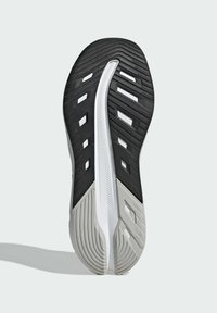 Black and white athletic shoe sole featuring textured rubber, grooves, and cutouts for traction and flexibility, with a streamlined shape.