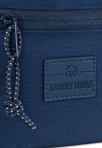 Navy-blaue Stofftasche mit Reißverschluss, strukturierter Oberfläche und einem genähten Lederetikett mit dem eingprägten Schriftzug "JOHNNY URBAN".