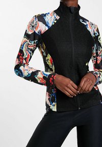 Kurtka z wielokolorowym zamkiem błyskawicznym, z czarnymi teksturowanymi panelami i żywymi kwiatowymi wzorami na rękawach. Elegancki, dopasowany krój.