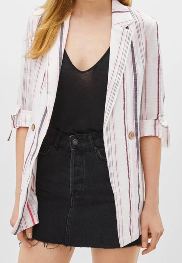 Randig kavaj i vitt, rosa och marinblått, med en enkel knappstängning, rullade ärmar och en avslappnad passform. Matchas med en svart kjol.