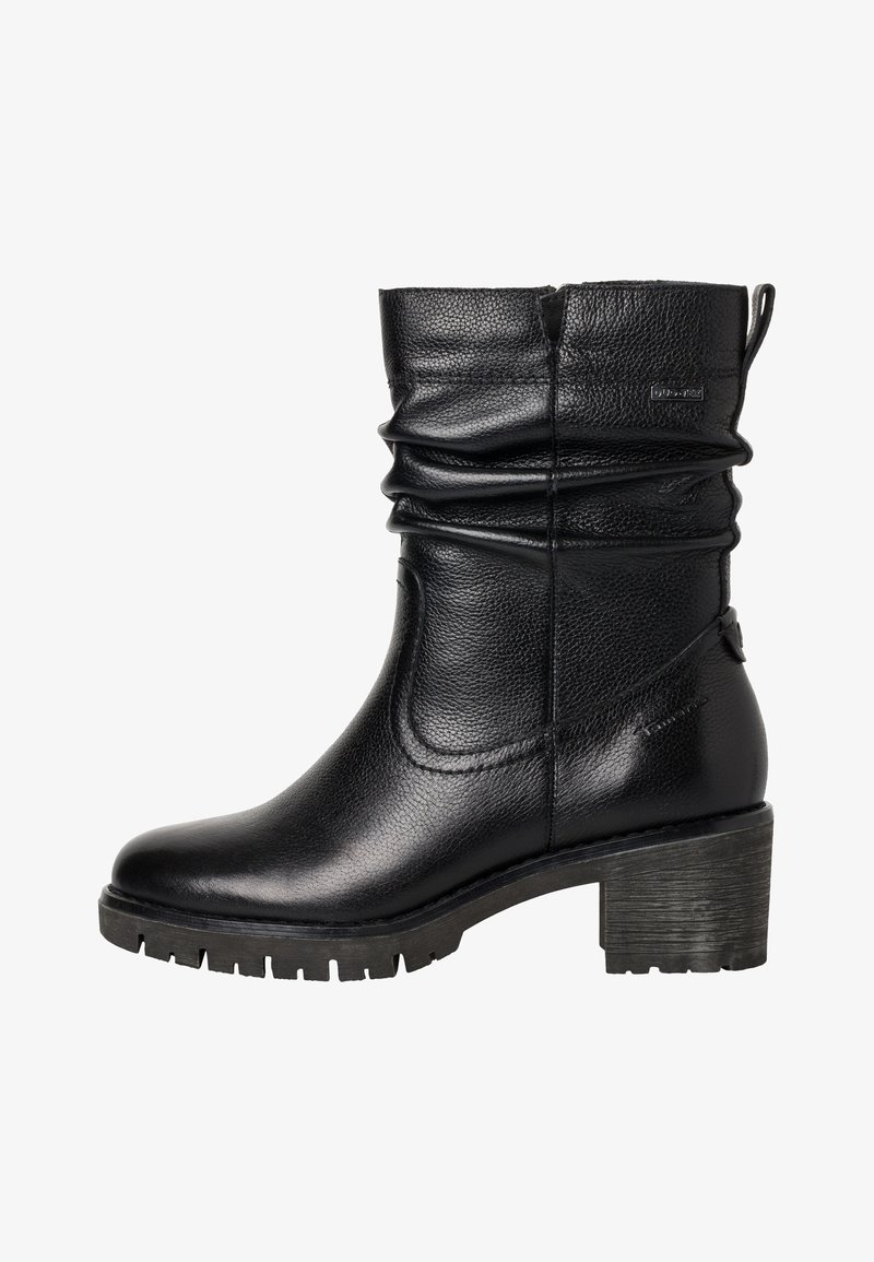 Botte en cuir noire mi-mollet avec tige souple, fente latérale, languette de maintien et talon ainsi que semelle épais texturés.